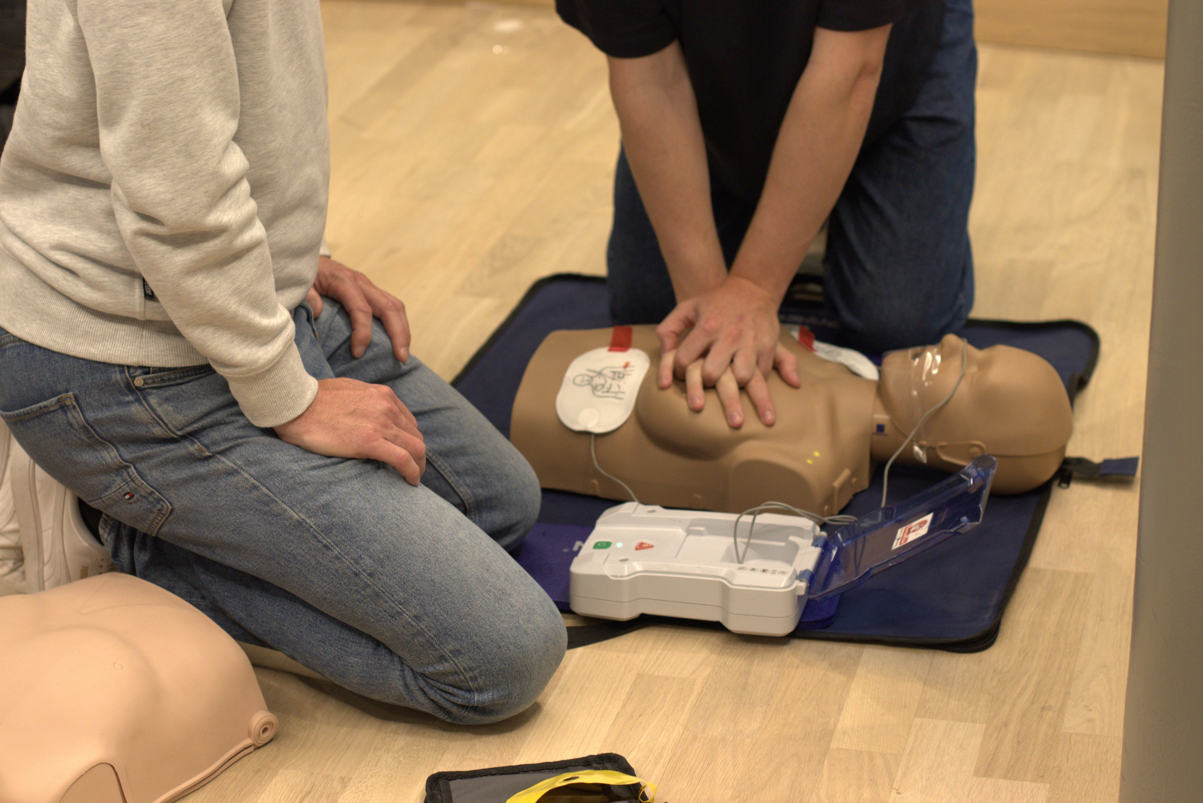 Reanimatietraining met AED elektroden duidelijk zichtbaar op een oefenpop